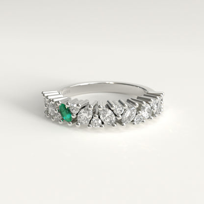 A 18k white gold diamond band ring featuring a row of marquise-cut and round diamonds with a single prominent green marquise emerald on the left, set against a clean white background.