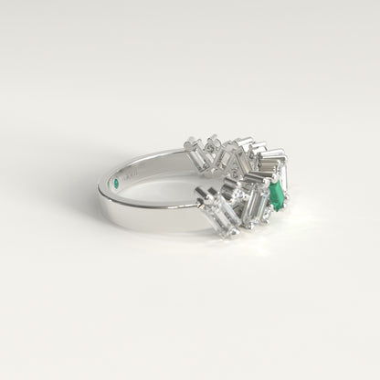 A white gold ring featuring a cluster of baguette-cut natural diamonds and a Colombian emerald baguette-cut gemstone, photographed on a clean white background. Lateral view