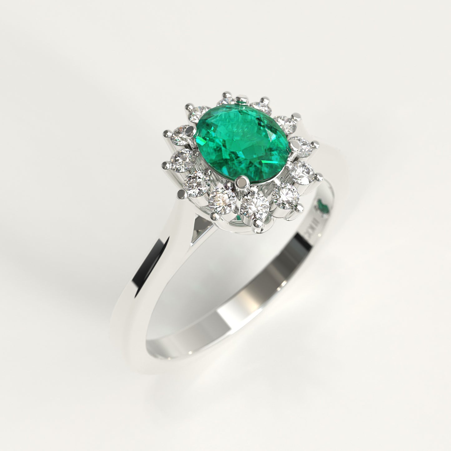 A white gold ring featuring a oval green emerald center surrounded by a halo of diamonds, set on a polished silver band against a white background.