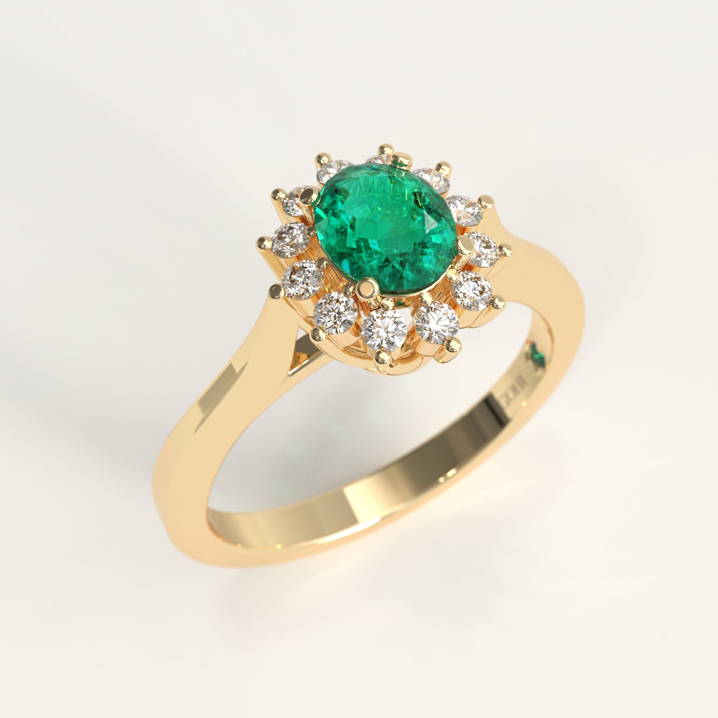 The same Bloom Ring crafted in 18k yellow gold, a green oval-cut Colombian emerald at the center, framed by a halo of round diamonds, set on a gently tapered yellow gold band.