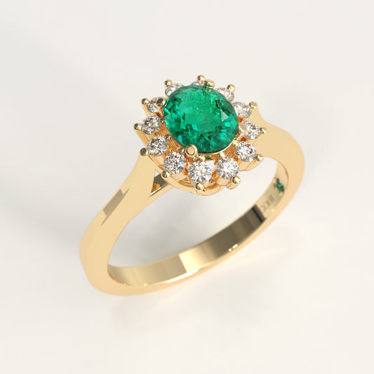 The same Bloom Ring crafted in 18k yellow gold, a green oval-cut Colombian emerald at the center, framed by a halo of round diamonds, set on a gently tapered yellow gold band.