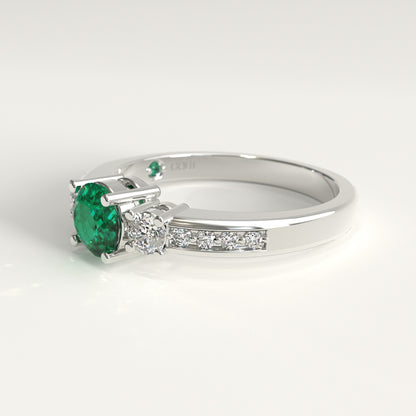 Lateral view of the ring's underside, showing the prong settings holding the emerald and diamonds from below, with the GOHI signature engraved inside the band beside a tiny hidden emerald.