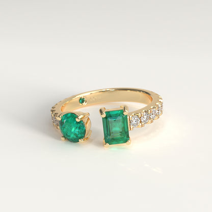 Duet Ring in 18k yellow gold, Colombian emerald and diamond toi et moi ring, Soiree Collection by GOHI. A fairmined gold ring with two emerald-cut colombian emeralds and small diamonds on a white background.